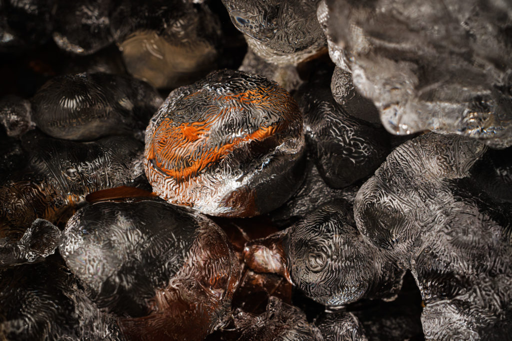 Glace texturée aux abords d’une cascade Macro de glace sculptée par le gel et le ruissellement, aux abords d’une cascade hivernale en Haute-Savoie. Texture fascinante et jeux de lumière.