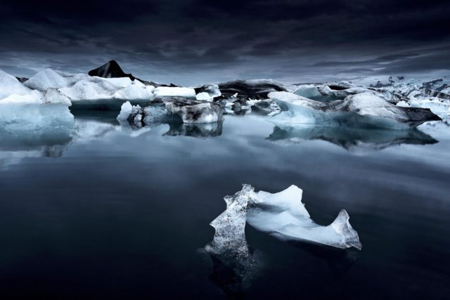 Icebergs bleus dans la lagune glaciaire de Jökulsárlón en Islande, photographie nocturne en juin sous une lumière sombre et mystérieuse